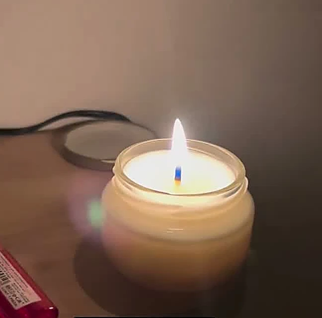 Vela de masaje encendida sobre una mesa
